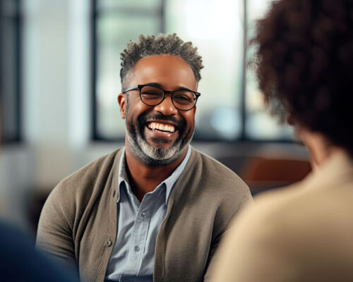 Man smiling during group therapy for addiction.