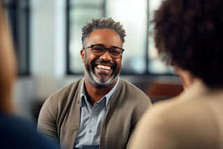 Man smiling during group therapy for addiction.