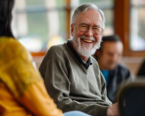 Many smiling during a session of group CBT for addiction.