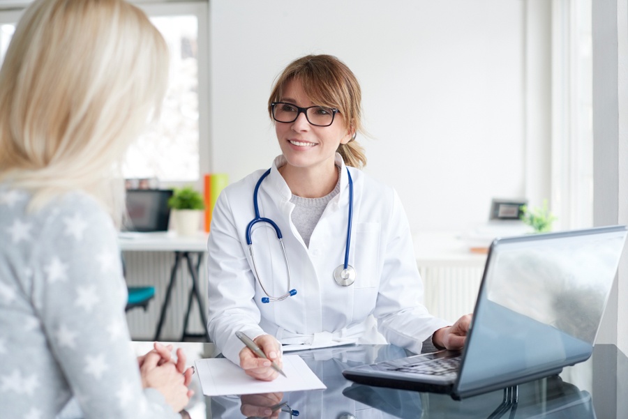 Doctor explaining alcohol withdrawal symptoms to young woman.